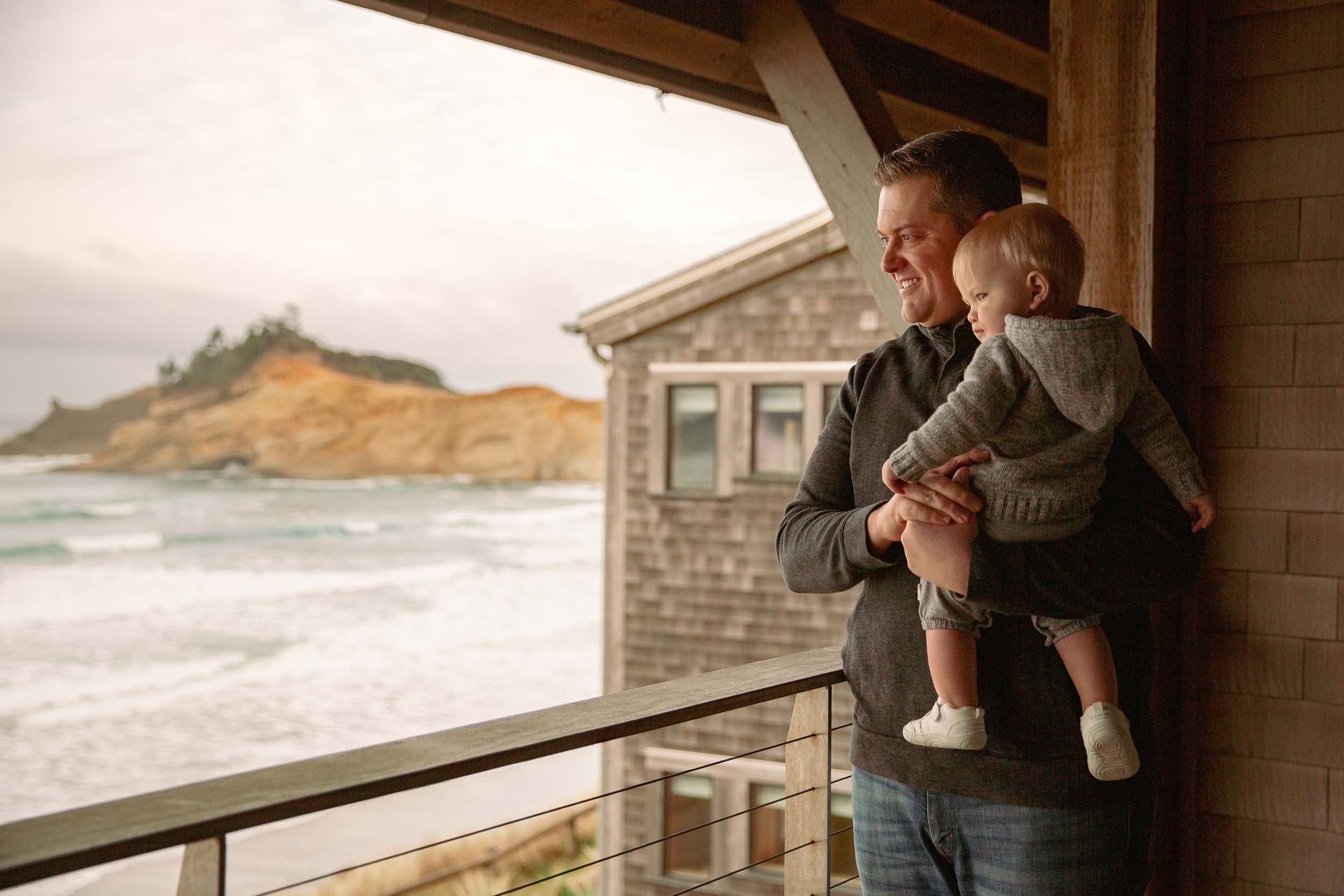 A man holding his baby on the balcony at Headlands