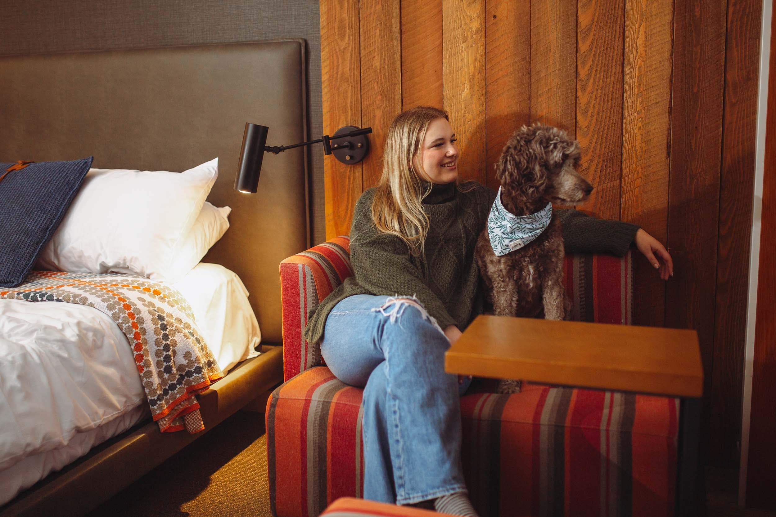 A woman and a dog sitting in a chair in a room at Headlands