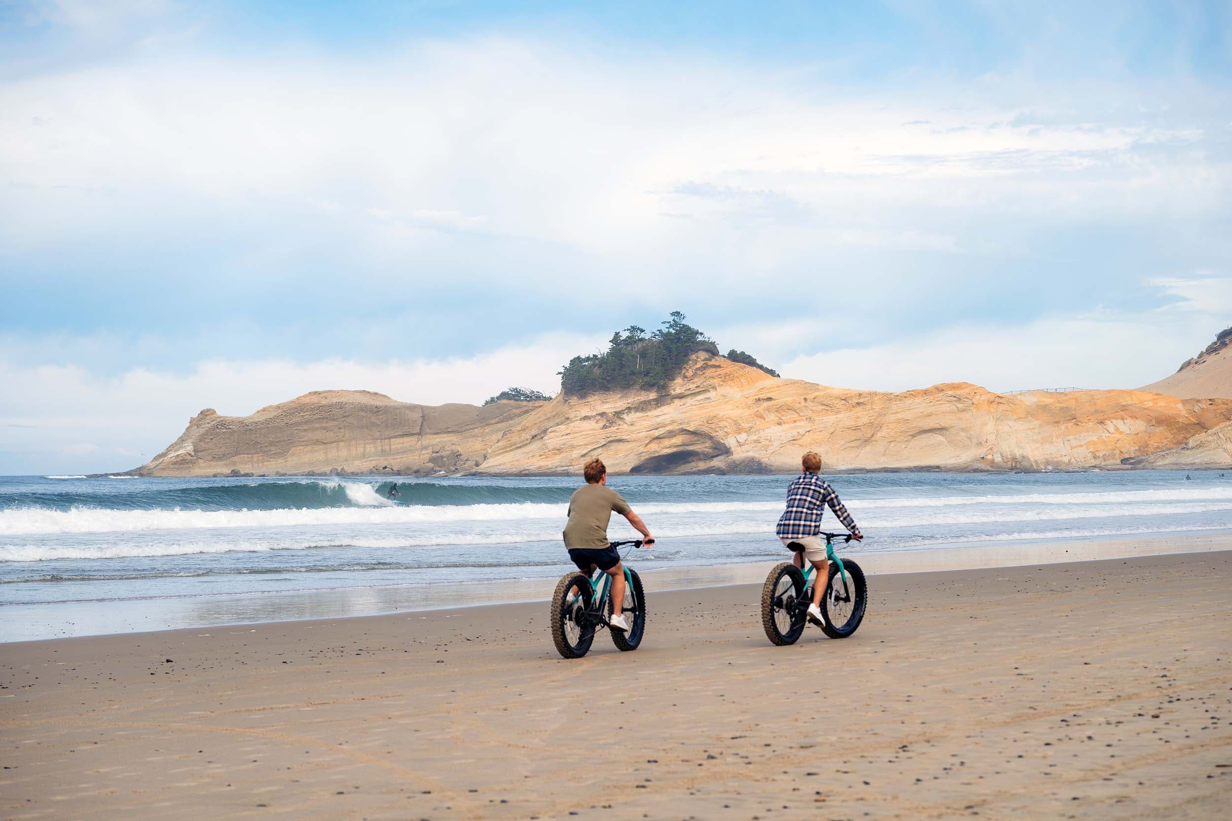 Two young boys biking on the beach at Cape Kiwanda near Headlands