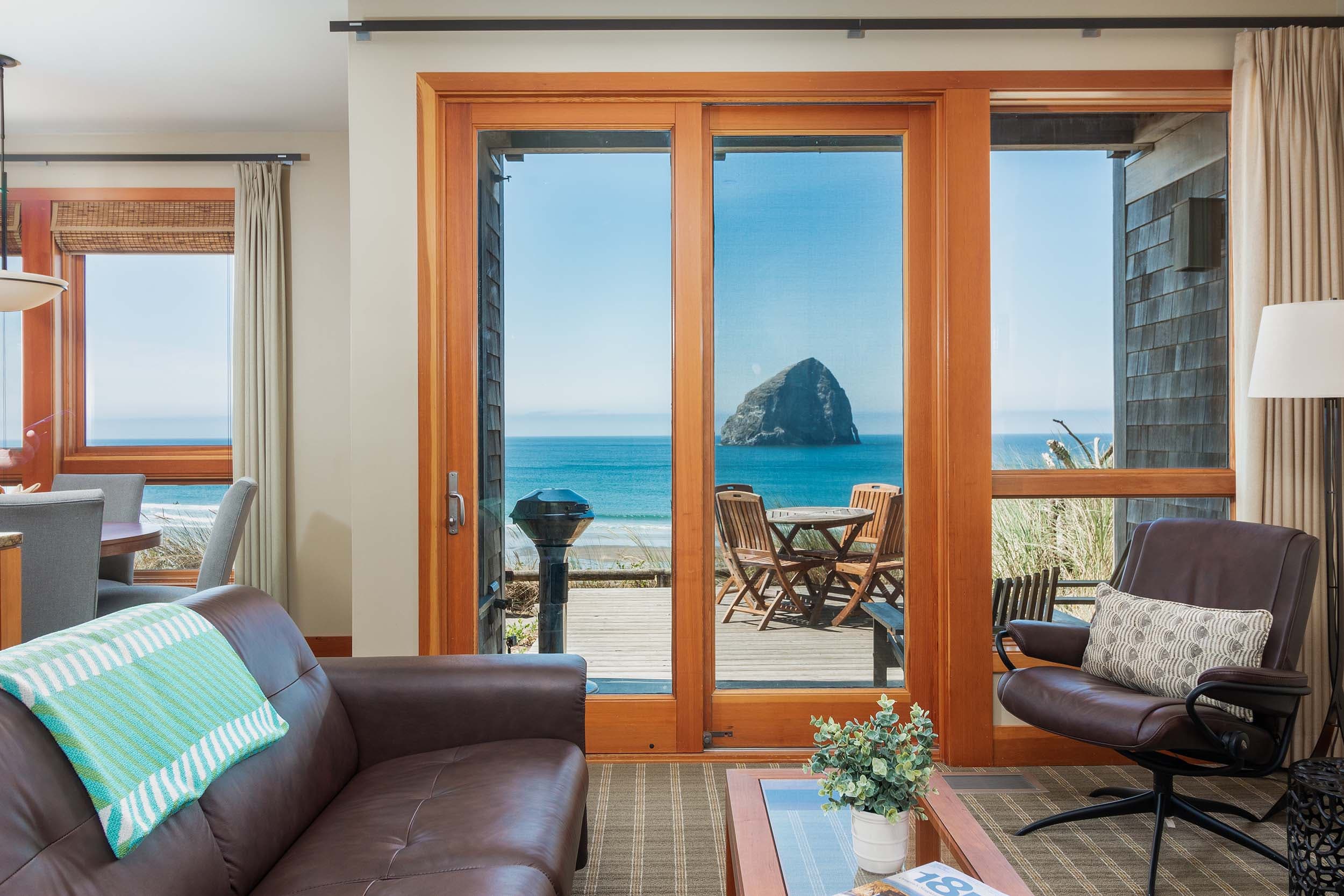 The living space with a couch, rocker and a view of Haystack rock in a 3 bedroom cottage at Headlands