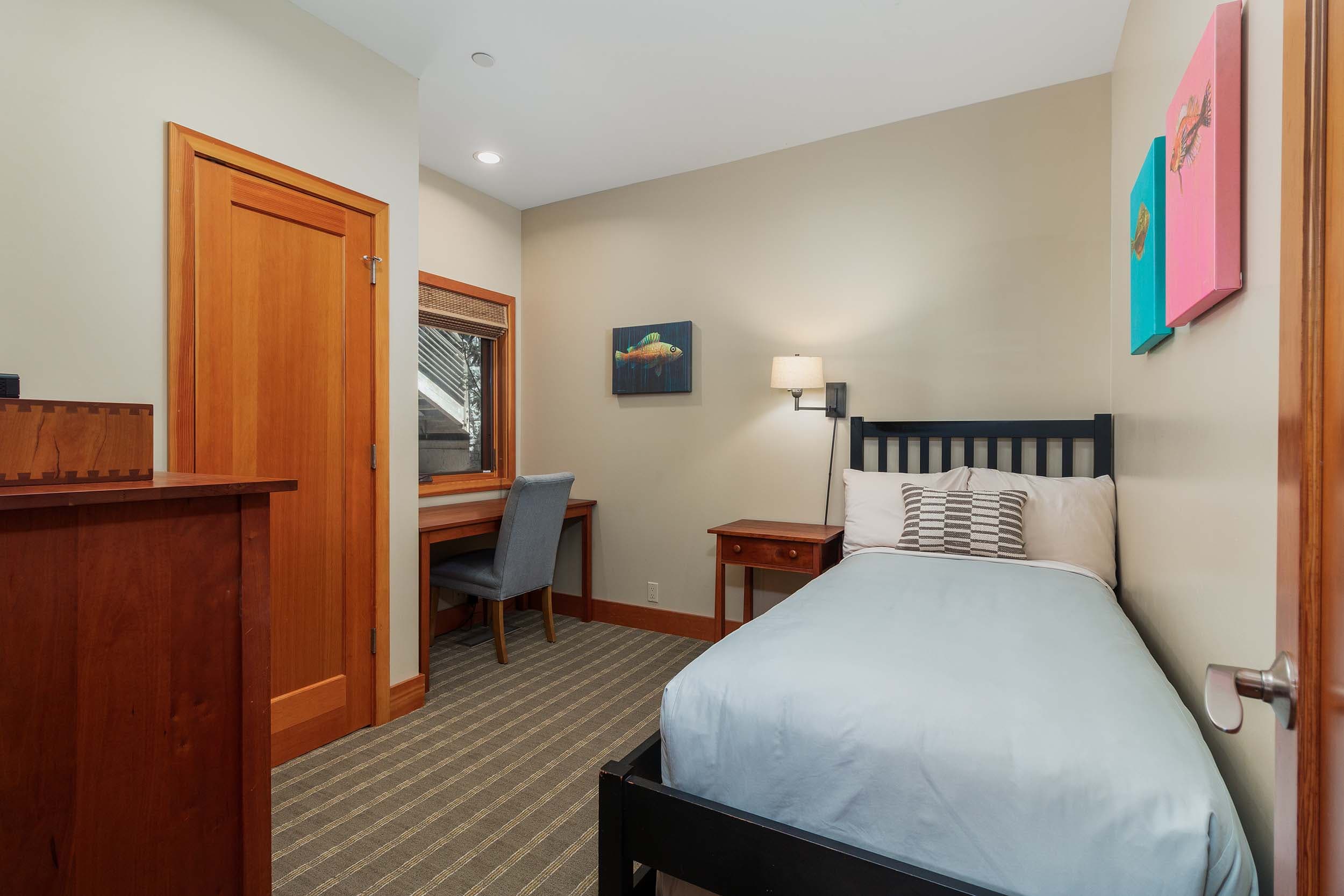 A twin bed and a desk in a 3 bedroom cottage at Headlands