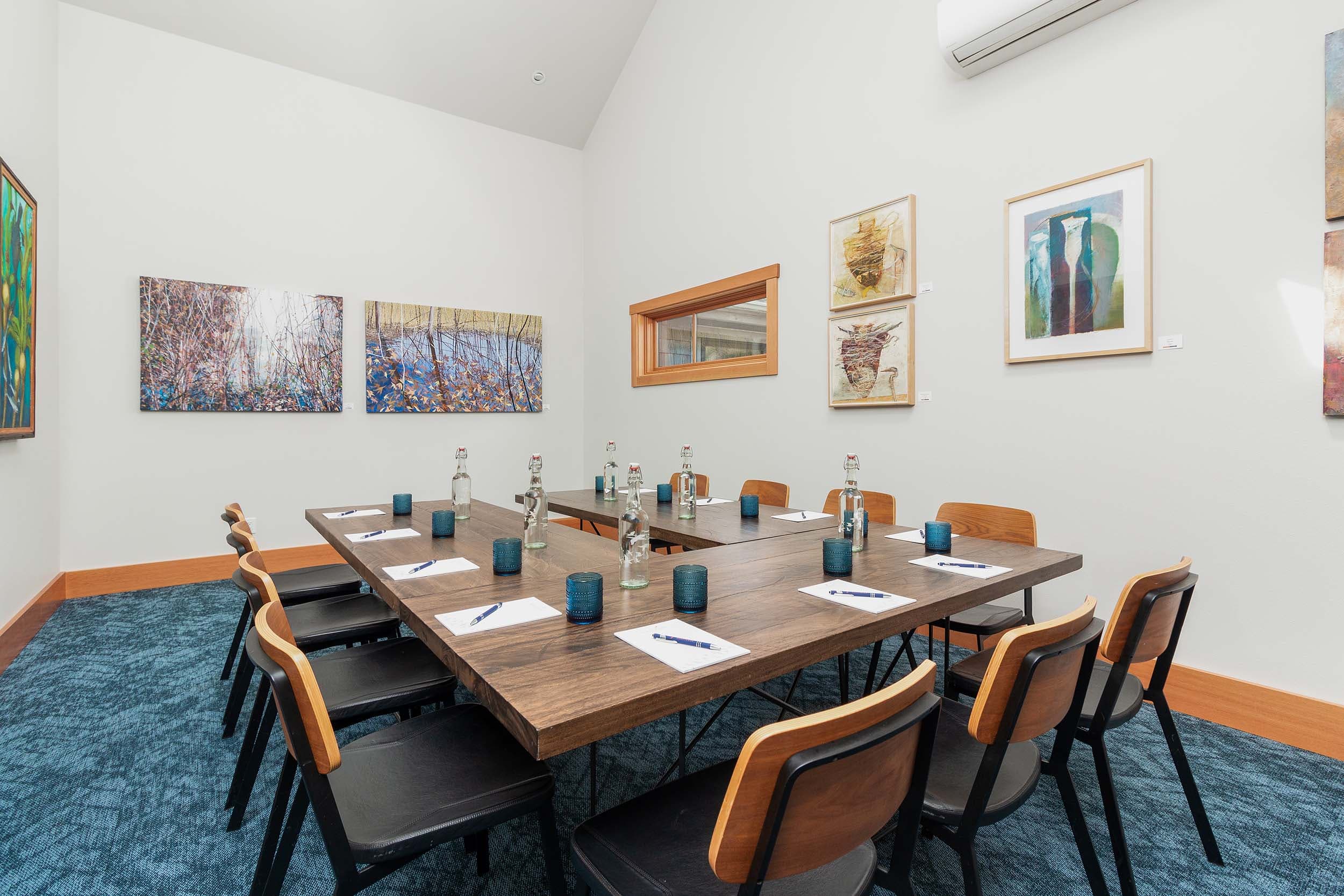 The Compass Room setup with 11 chairs, glasses, pads of paper, and pens at Headlands