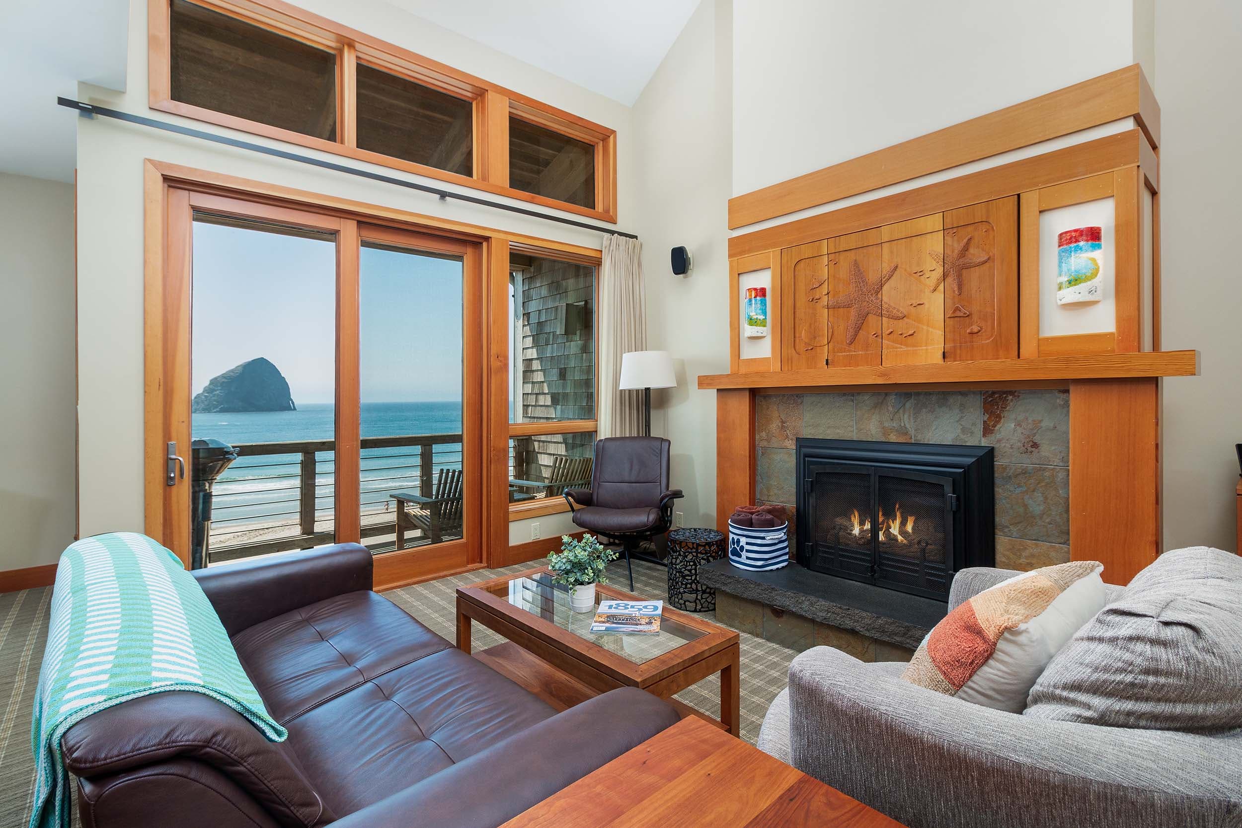 The living space with relaxing seating, a fireplace and a view of the ocean in a 2 bedroom ADA cottage at Headlands