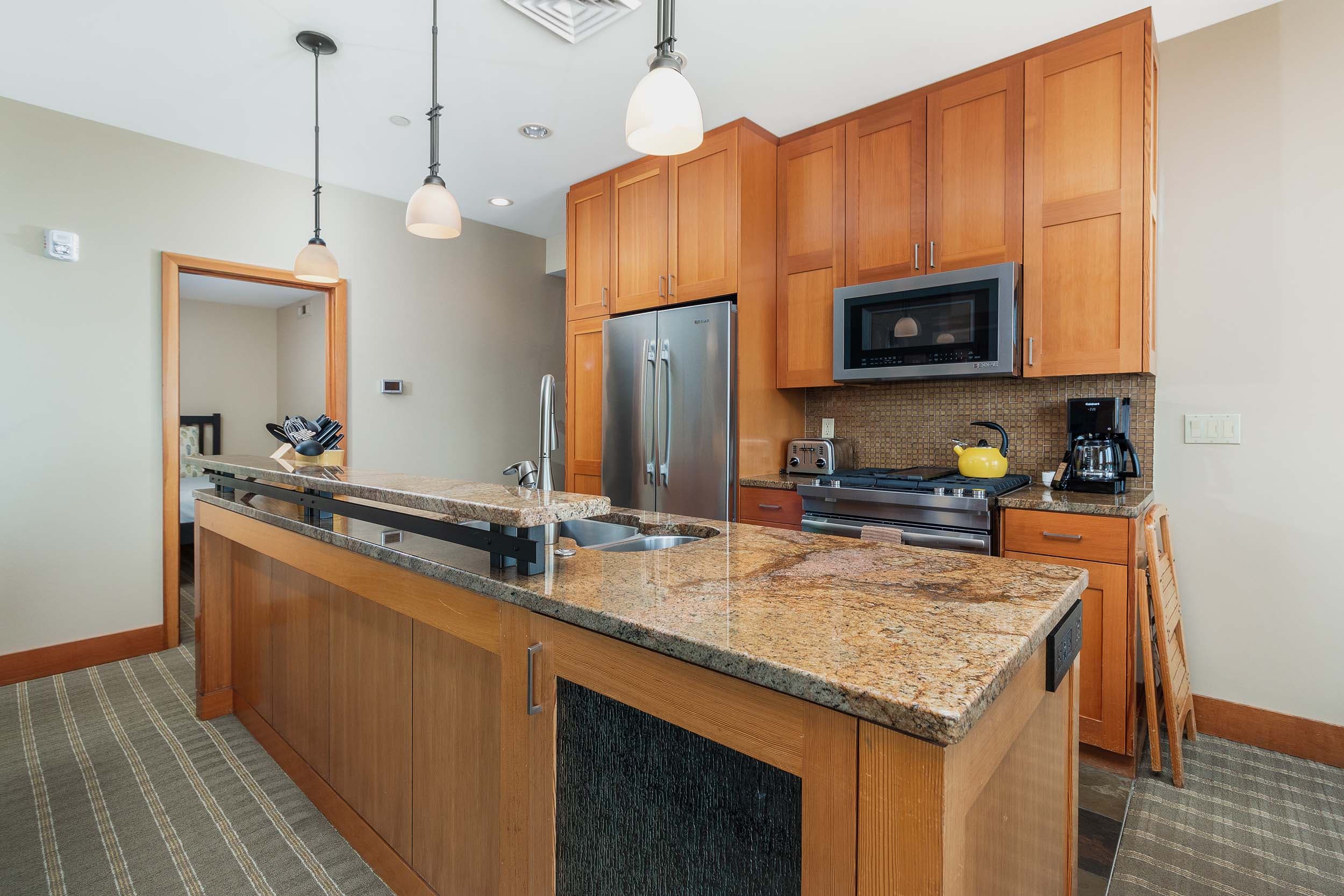 The kitchen with marble counter tops and modern appliances in a 2 bedroom ADA cottage at Headlands