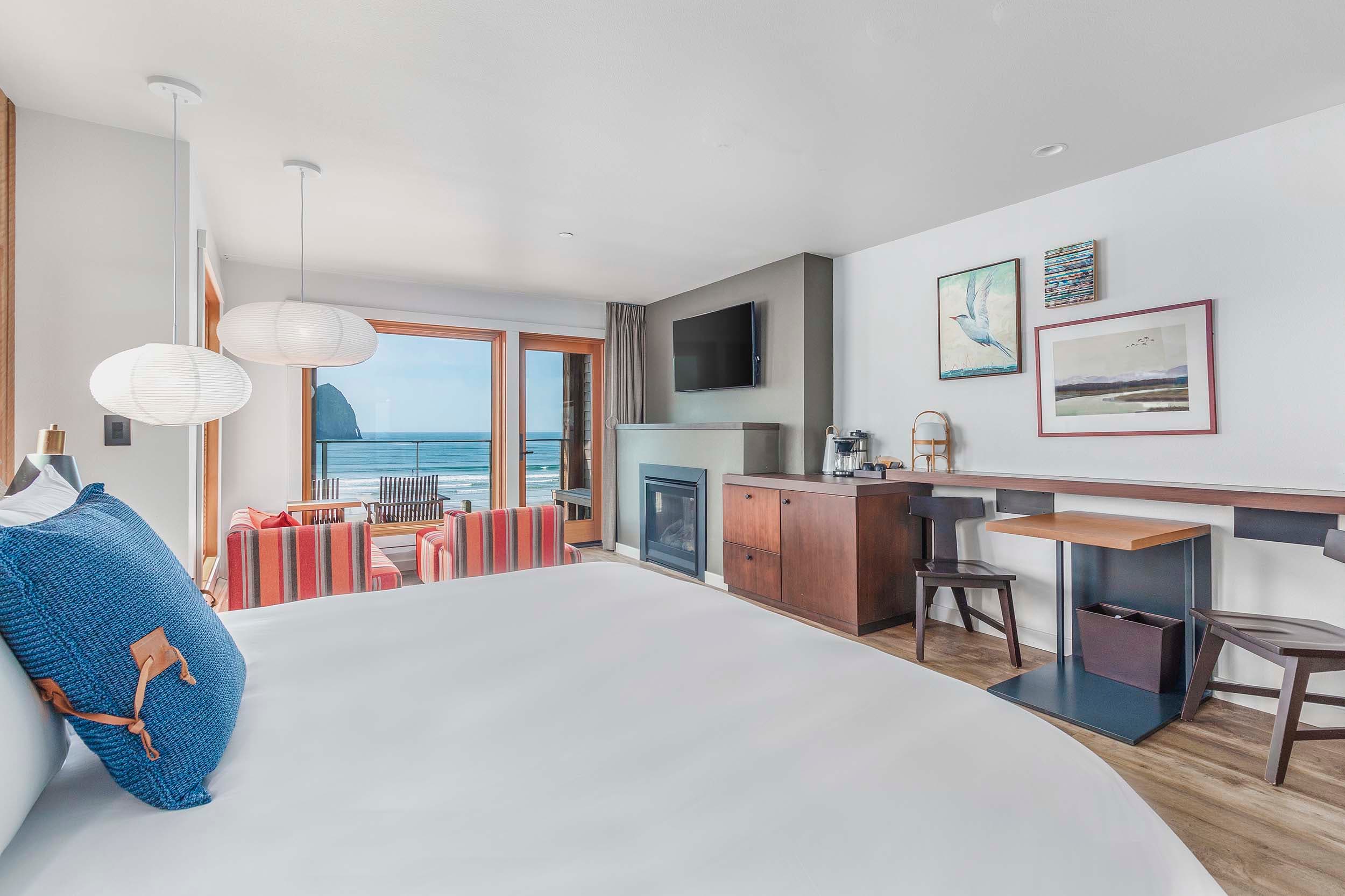 A sleeping area with a desk and lots of windows looking onto the beach in a King Sunlight Accessible at Headlands