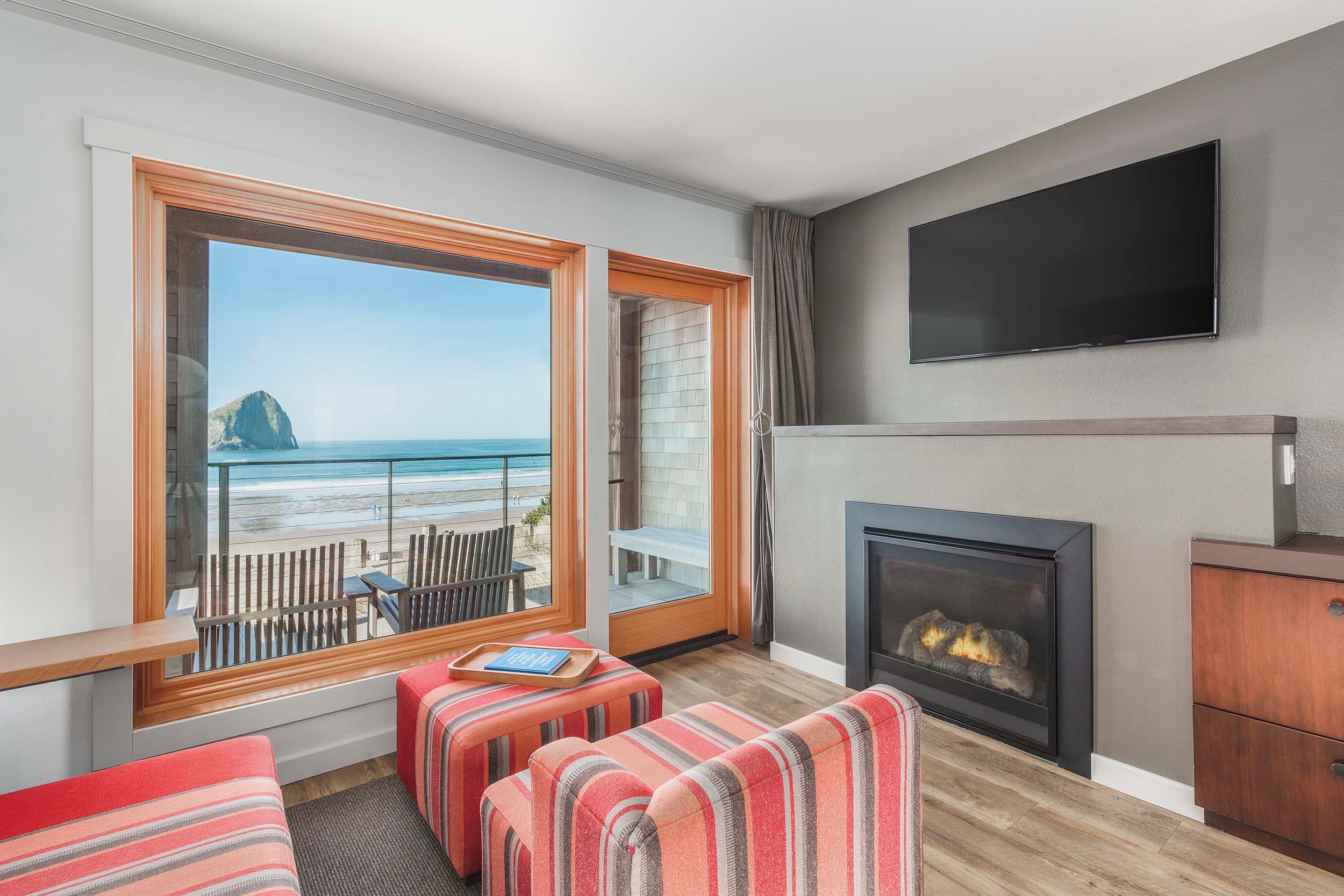 The cozy lounge area with a fireplace and access to the balcony in a King Sunlight Accessible at Headlands