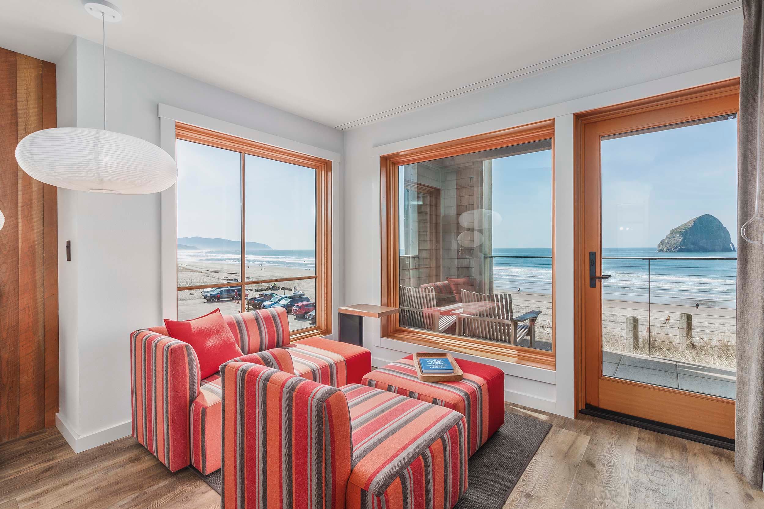 A lounge area with lots of windows looking onto the beach in a King Sunlight Accessible at Headlands