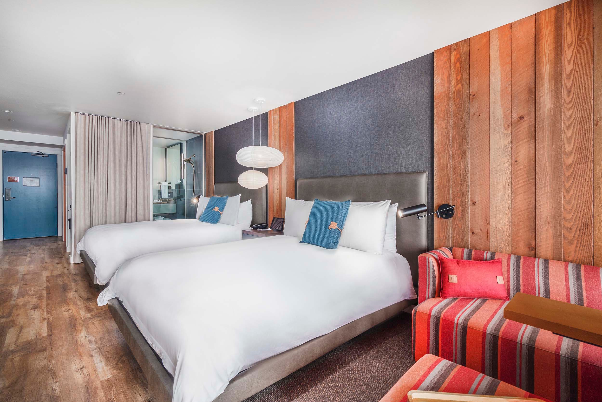 Two queen beds and a lounge space in a Two Queens Signature room at Headlands