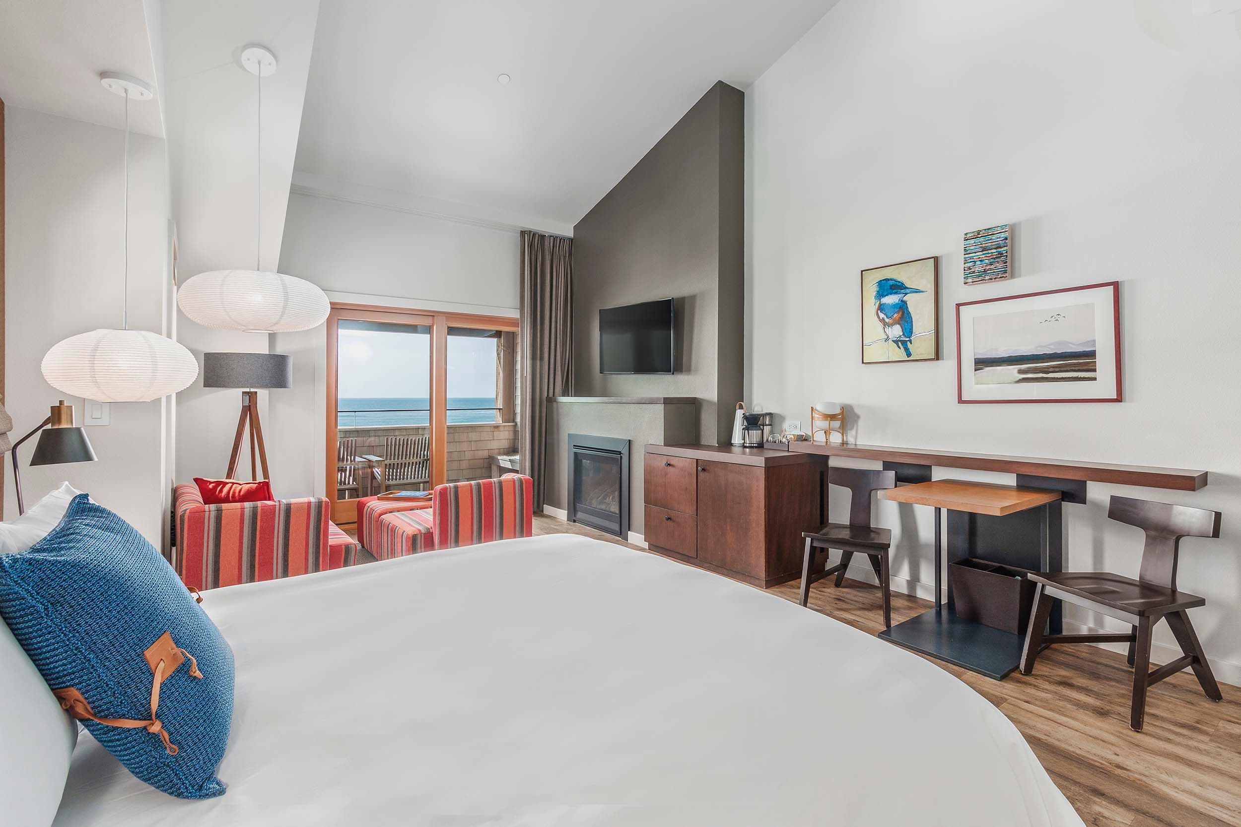 A king bed and living space with a fireplace and TV in a King Sunlight Top Floor at Headlands