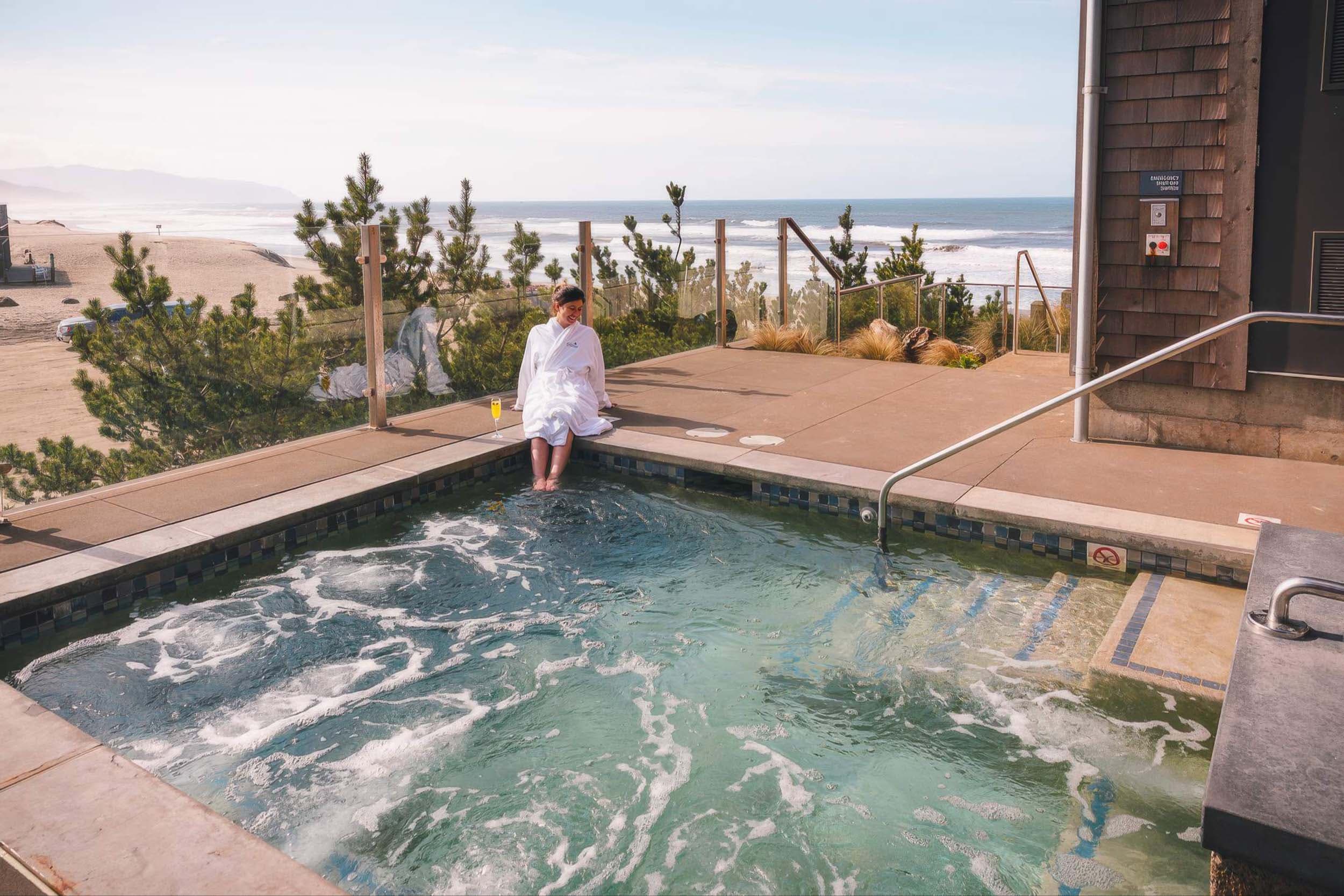 A woman dipping her toes on the hot tub at Headlands