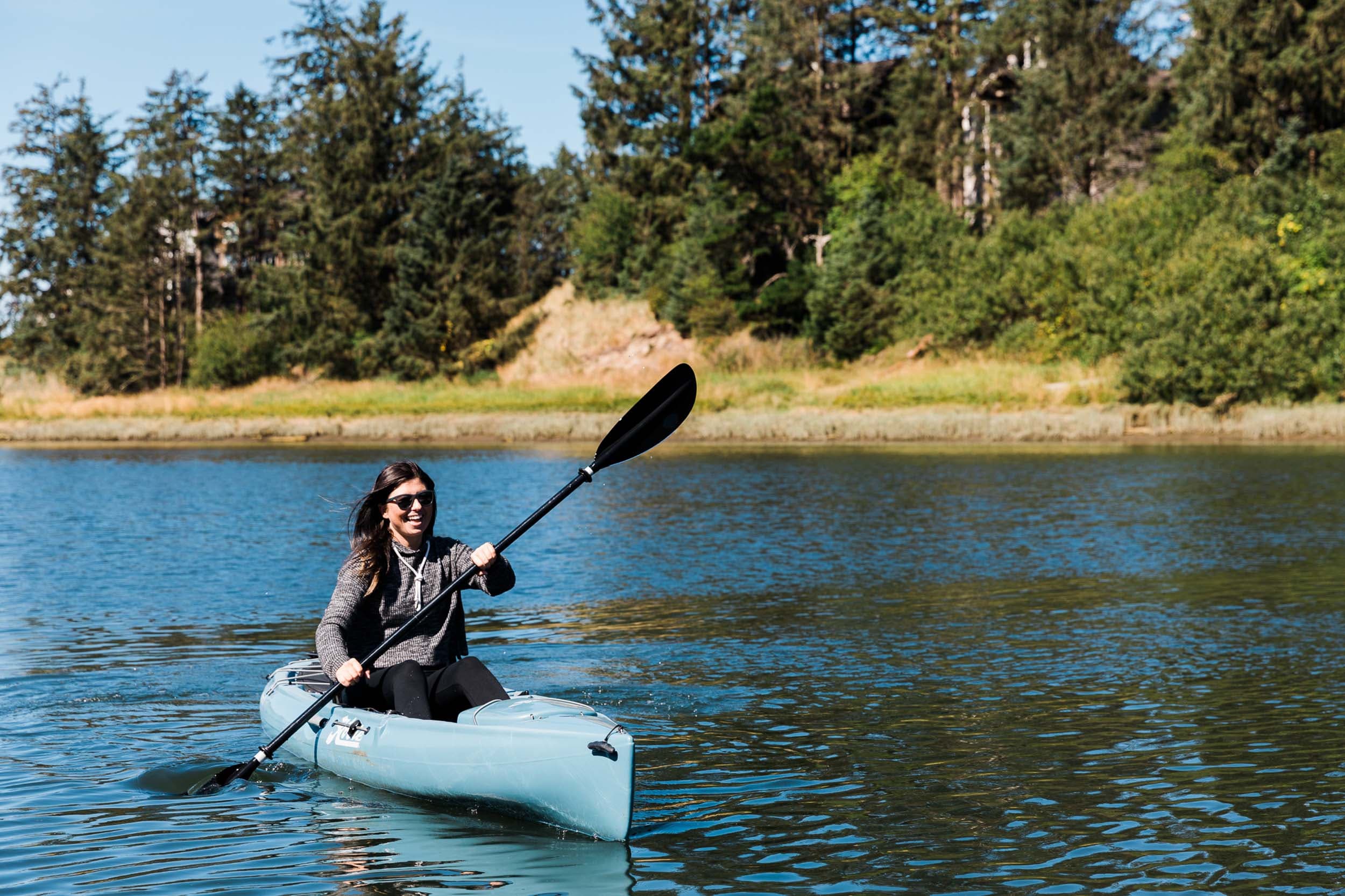 A woman laughing in a kayak on a Nestucca River Excursion