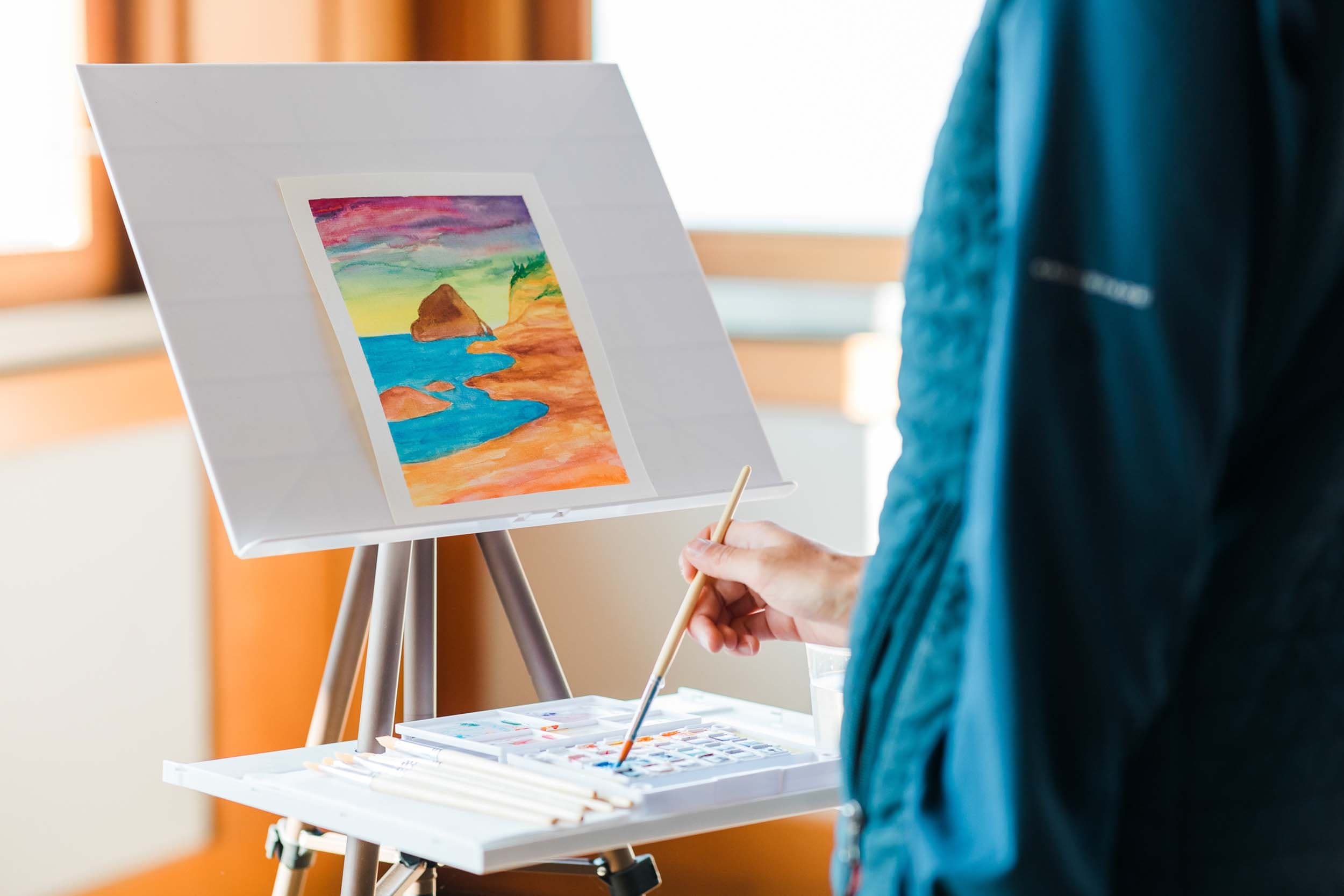 A person doing some water colors of Haystack Rock