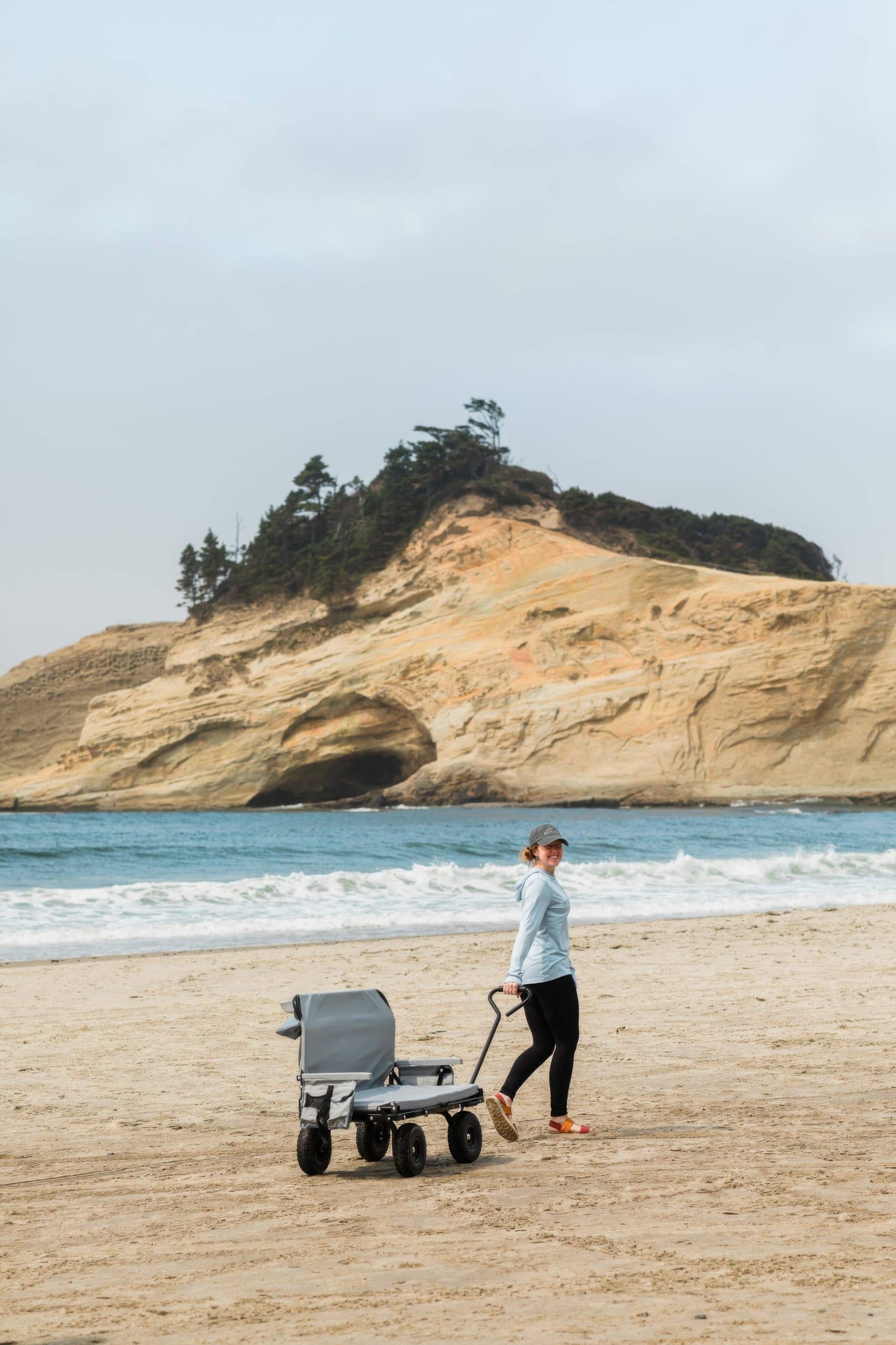 A woman walking with a beach wagon near Headlands