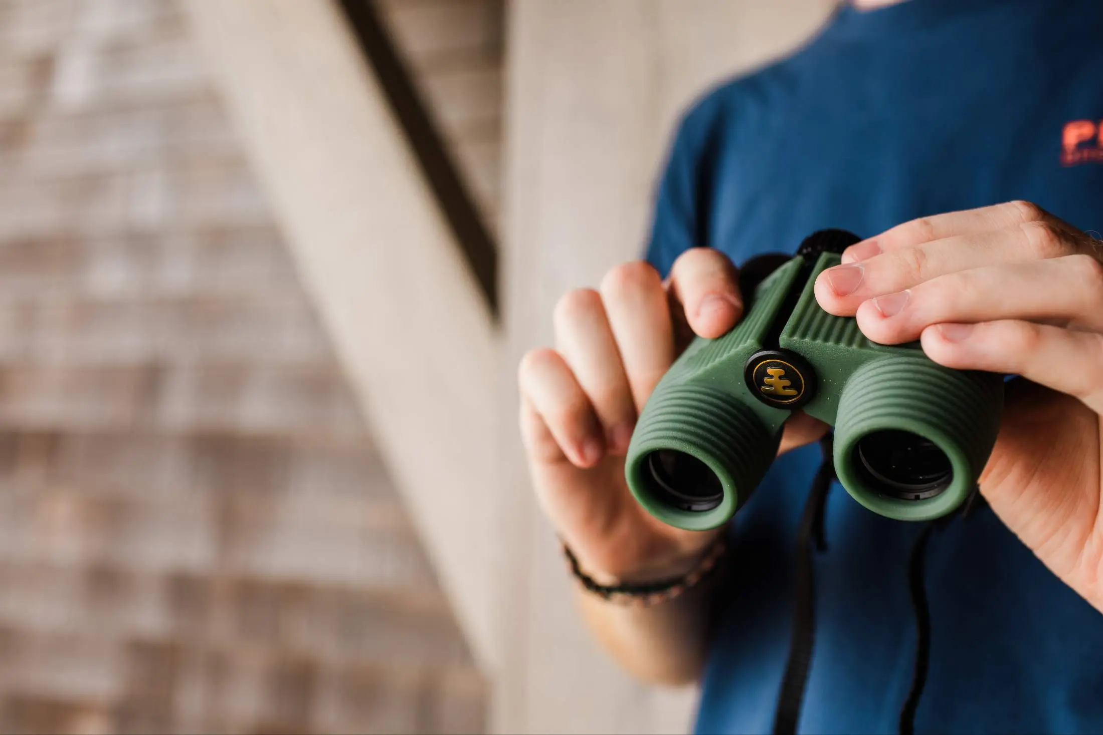 A man holding binoculars on a balcony at Headlands