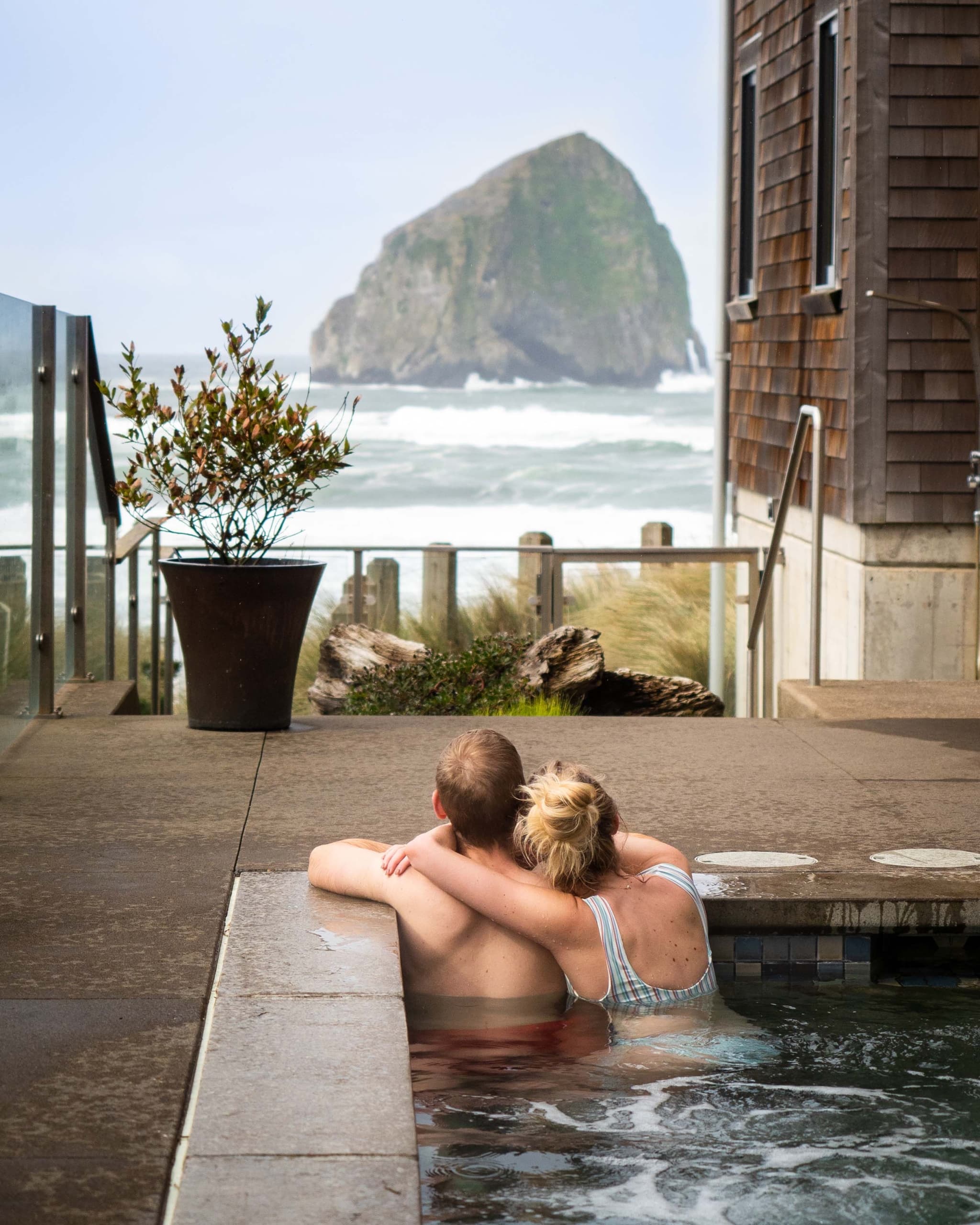 Two people embracing from the outdoor pool looking at the ocean at Headlands