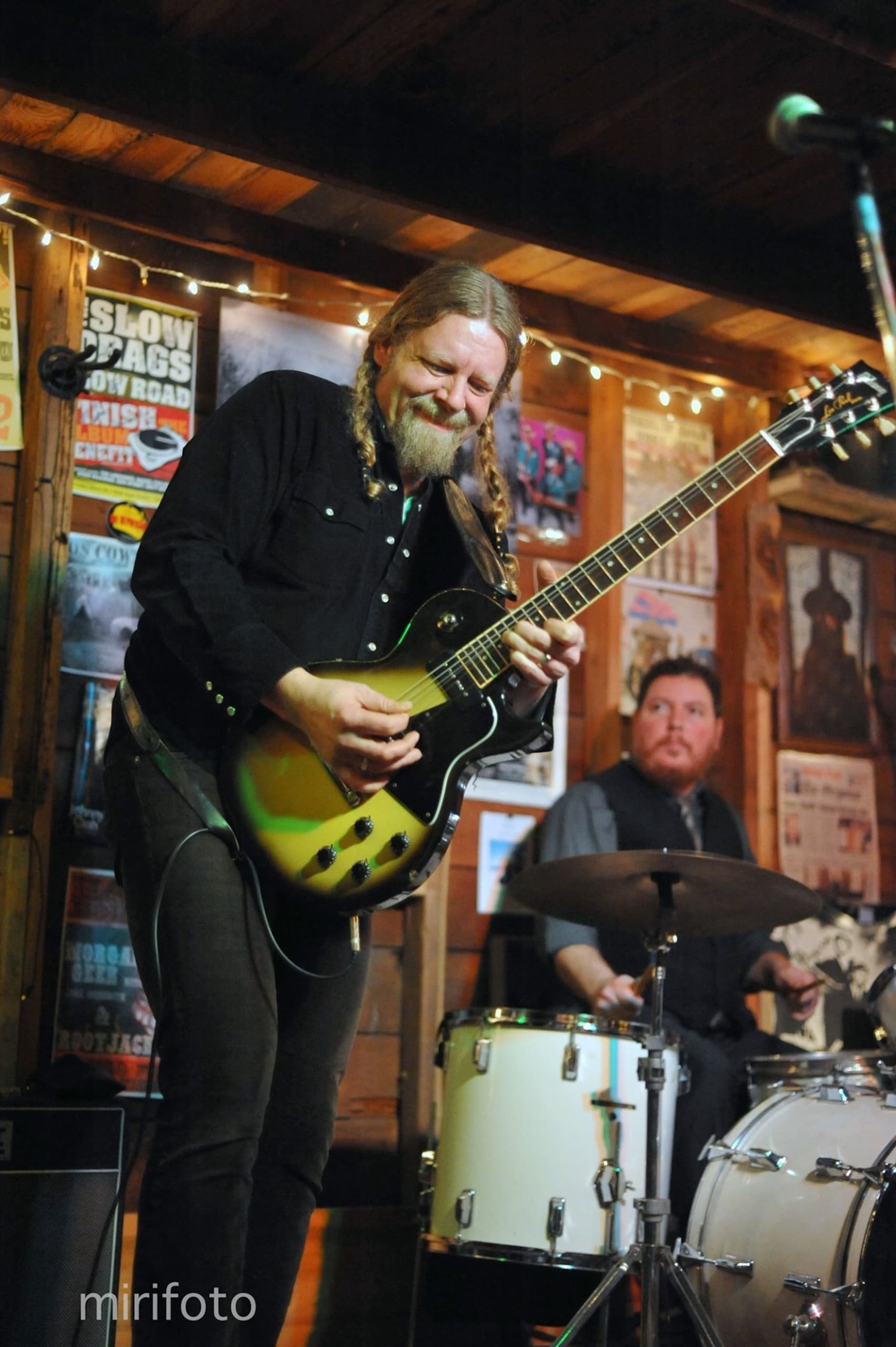 Kris Stuart playing guitar on stage at Meridian Restaurant & Bar